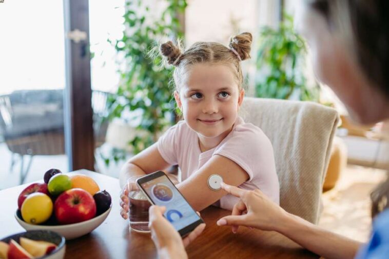 girl with CGM device measuring blood glucose