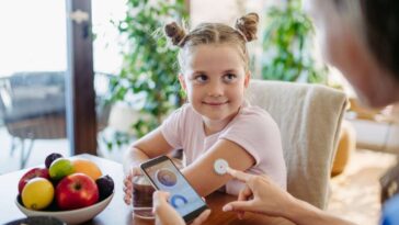 girl with CGM device measuring blood glucose