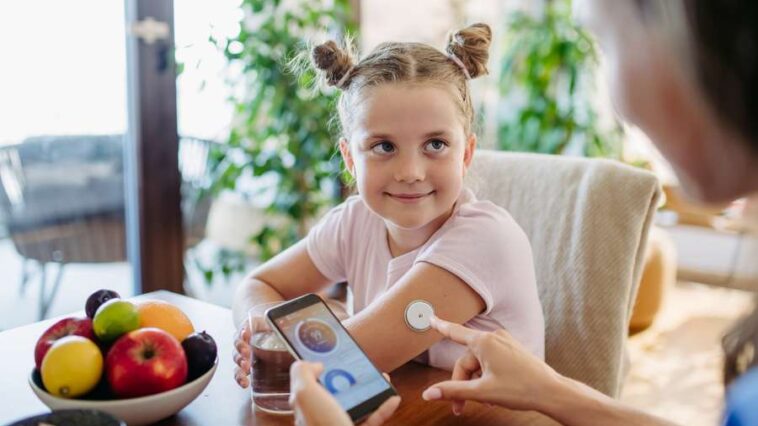 girl with CGM device measuring blood glucose