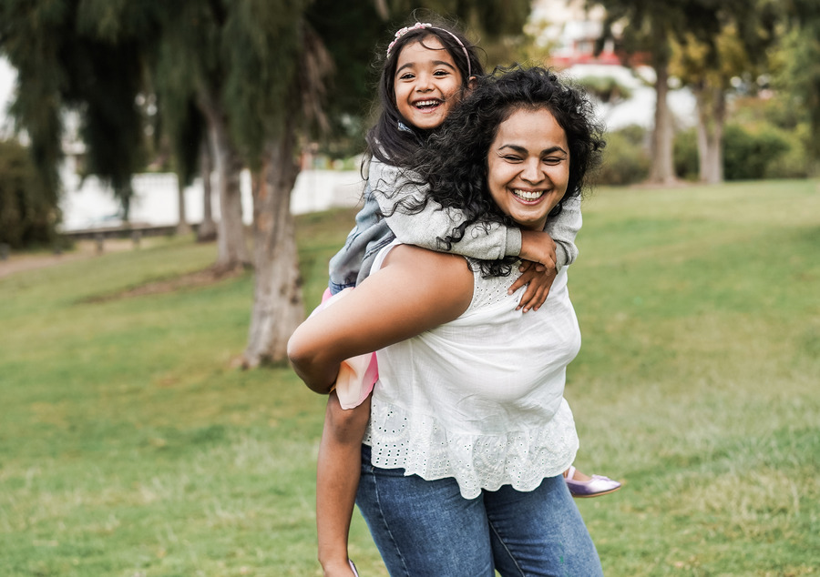 indian woman with her daughter running in the park